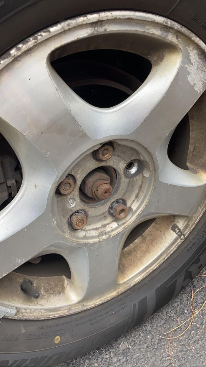 Close-up of a damaged car wheel rim missing lug nuts, illustrating real-life situations where anything is edible once.