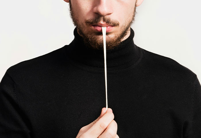 Man in black sweater taking a hygiene test with a cotton swab, highlighting poor hygiene issues affecting partners.