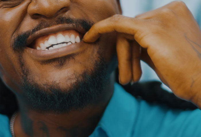 Close-up of a man’s smile showing teeth, emphasizing the importance of good hygiene to avoid partners gagging.