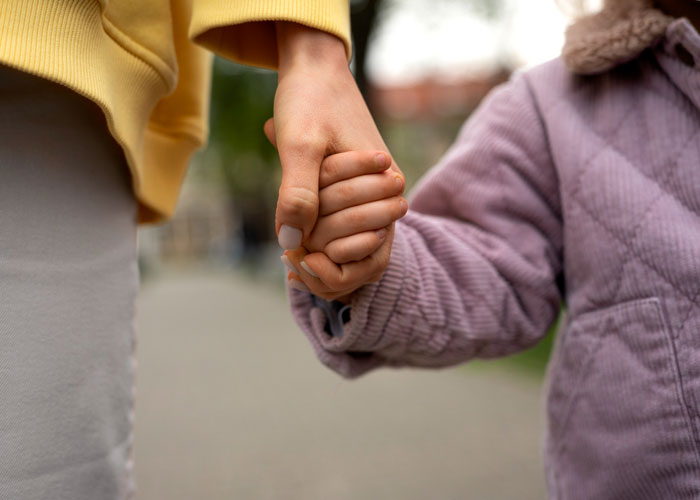 Close-up of two hands holding each other, symbolizing family support and stepbrother financial responsibility conflict. Close-up of two hands holding each other, symbolizing family support and stepbrother financial responsibility conflict.
