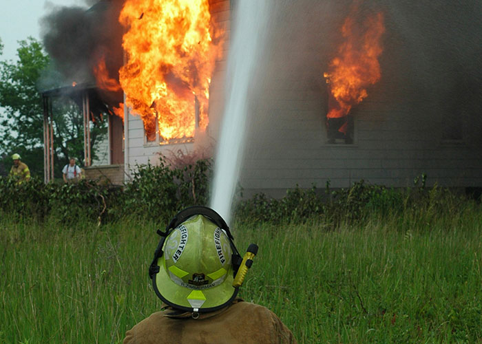 Firefighter spraying water on a burning house as landlord finally gets rid of horrible tenants with a chance for revenge.