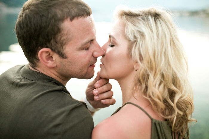 Couple in an intimate moment by the water, hinting at hidden affairs and trust issues in their relationship.