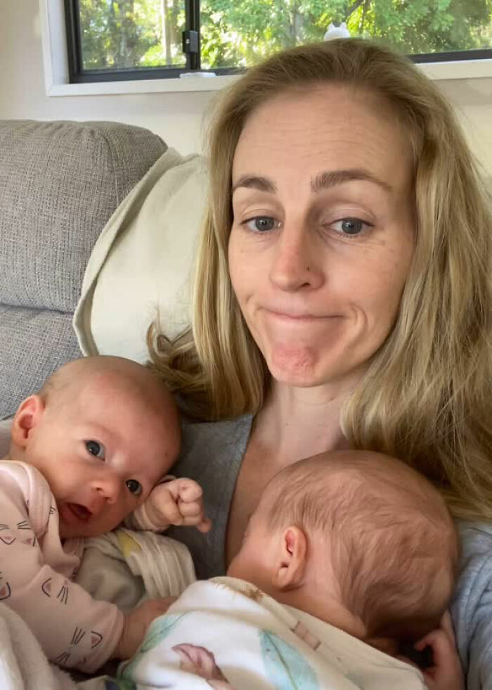 Woman with two infants at home, highlighting health risks of breastfeeding stigma and challenges faced by mothers.