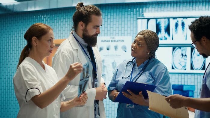 Doctors examining X-rays and discussing unusual medical cases of patients who defied every medical odd in a hospital setting.
