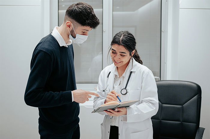 Doctor and patient discussing health myths, with doctor taking notes in a medical office setting.