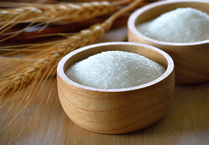 Two wooden bowls filled with white granulated substance representing medical myths about sugar and health in doctors’ discussion.
