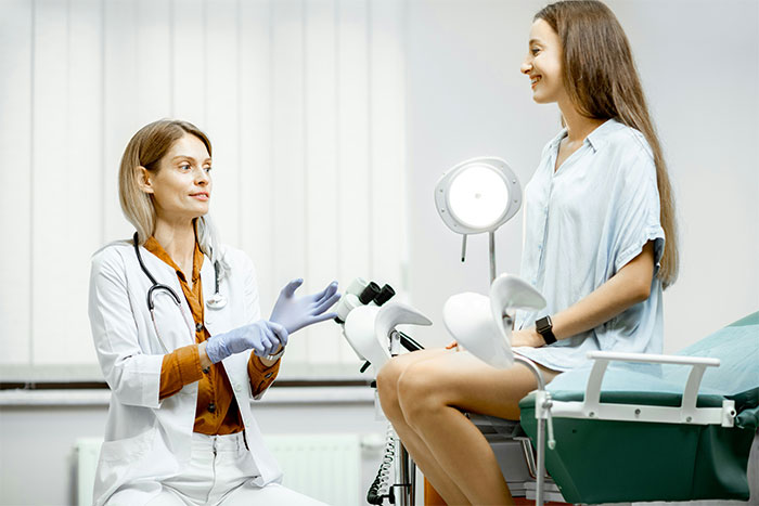 Doctor talking to a young woman during a medical exam, illustrating doctors exposing common health myths.