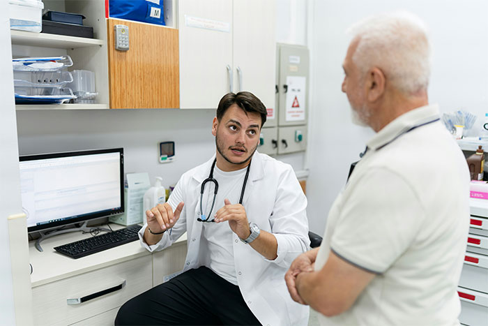 Doctor with stethoscope explaining medical myths to elderly patient in a clinical office setting.