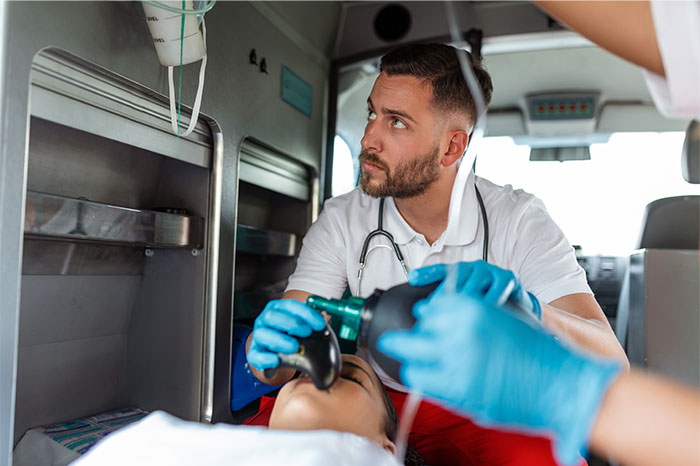 Paramedic in ambulance providing emergency oxygen to patient, illustrating fake illness attempts instantly exposed.