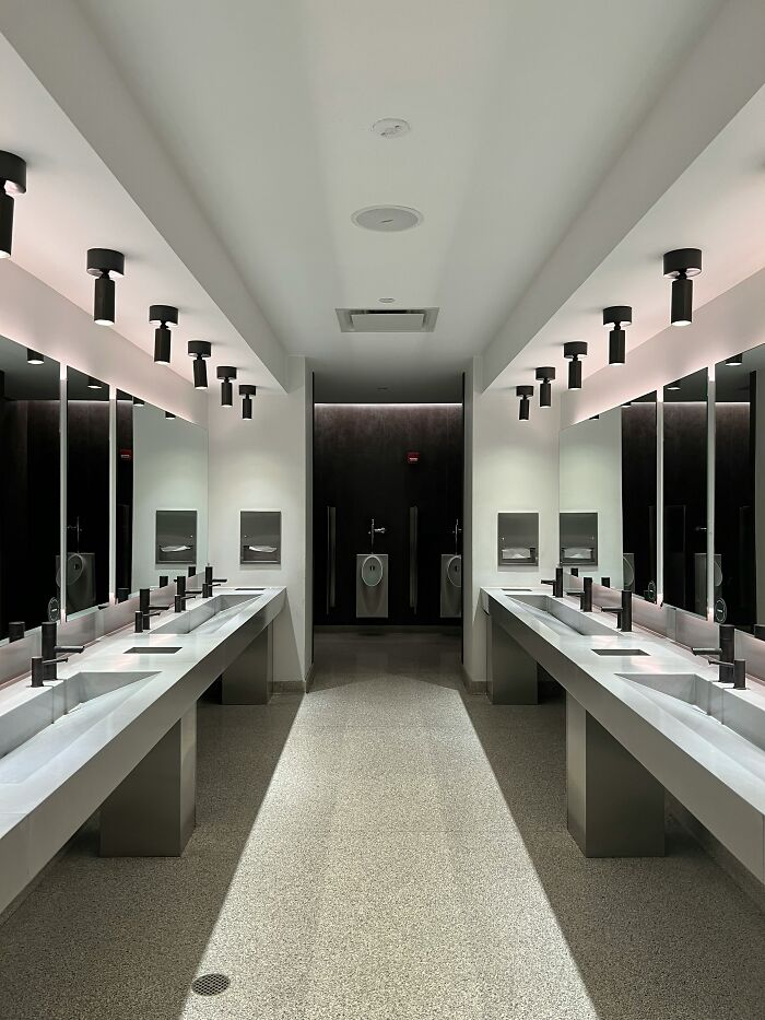 Modern public restroom interior with sinks and mirrors, illustrating patients trying to fool doctors with ridiculous lies.