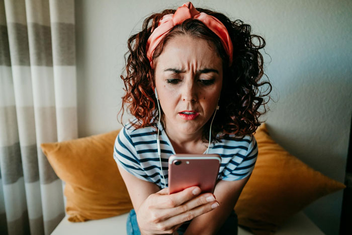Woman with headband looking at phone with concern, depicting emotions related to dog shelter and police involvement.