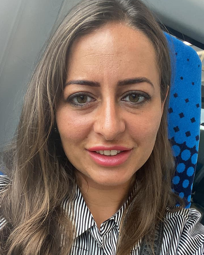 Young woman smiling in casual striped shirt, symbolizing a domestic violence victim whose life was saved by Siri.