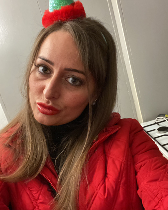 Woman in a red jacket and festive headband, symbolizing a domestic violence victim saved by Siri during an attack.