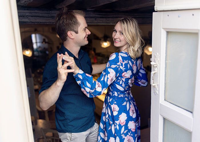A smiling couple dancing closely indoors, illustrating moments from stories about people living double lives.