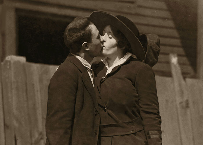 Vintage sepia photo of a couple kissing, illustrating people who tried living double lives to fool others.