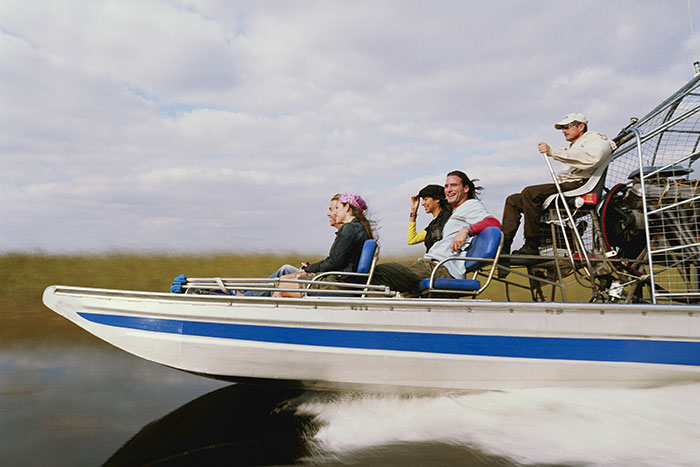 A group of people enjoying a fast boat ride on the water, illustrating unhinged company credit card use cases.