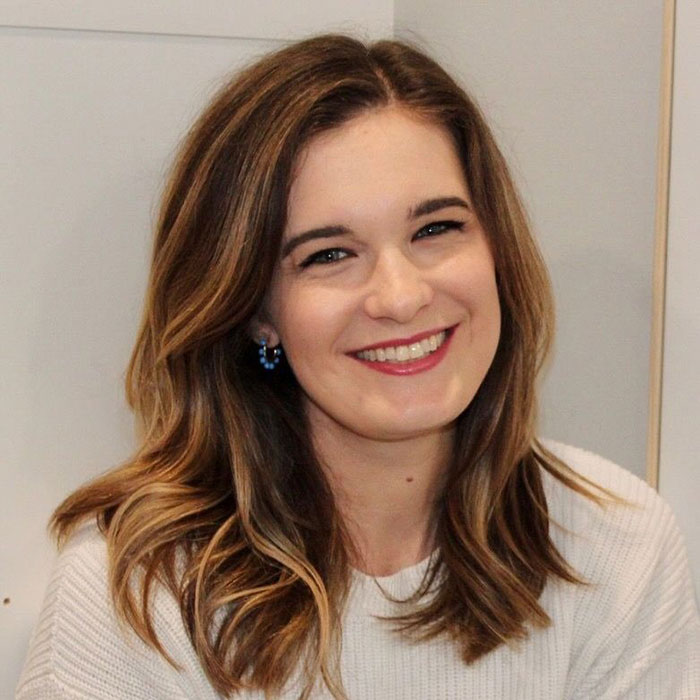 Smiling woman with light brown hair and blue earrings sharing viral story about mom telling 6YO daughter about Taylor Swift wedding.