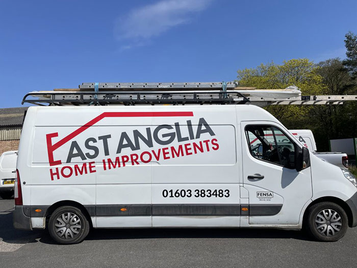 White van with East Anglia Home Improvements logo parked outside under clear blue sky White van with East Anglia Home Improvements logo parked outside under clear blue sky