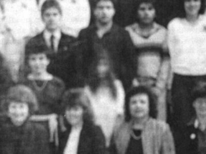 Black and white group photo with one blurred face, illustrating strange and unexplained histories in vintage images.