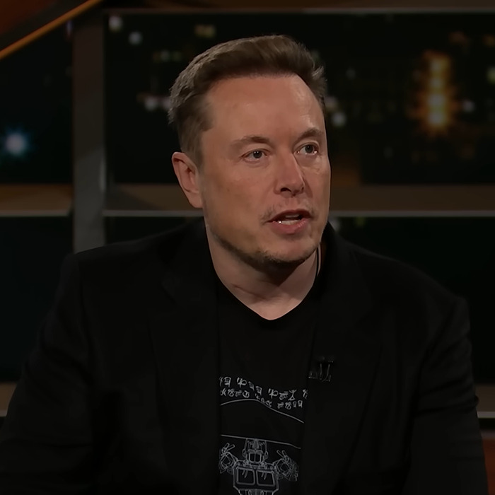 Elon Musk speaking in a studio interview, wearing a black blazer and graphic t-shirt, discussing donations for Iryna Zarutska murals. Elon Musk speaking in a studio interview, wearing a black blazer and graphic t-shirt, discussing donations for Iryna Zarutska murals.