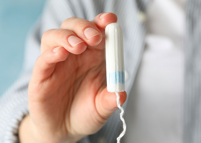 Close-up of hand holding a tampon during a doctor’s appointment illustrating hilariously embarrassing moments.