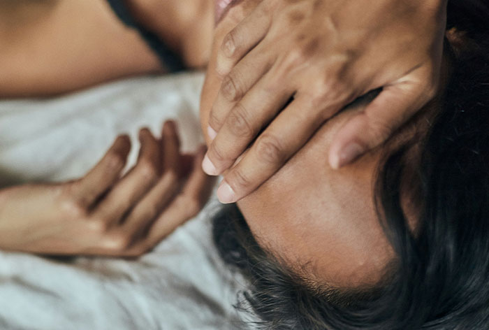 Healthcare worker holding a patient's head, showing care and concern in a close-up medical setting.