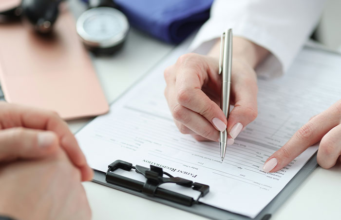 Healthcare worker filling out a patient registration form, highlighting the critical moments in patient care stories.