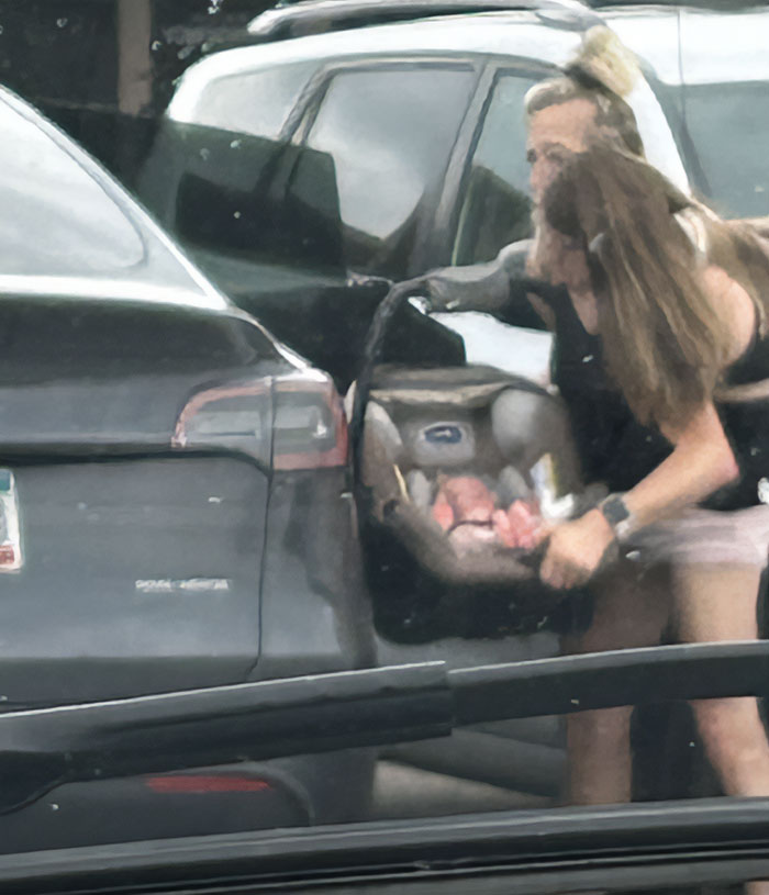 Two women with a baby in a car seat, highlighting after conjoined twins Abby and Brittany seen with a baby.