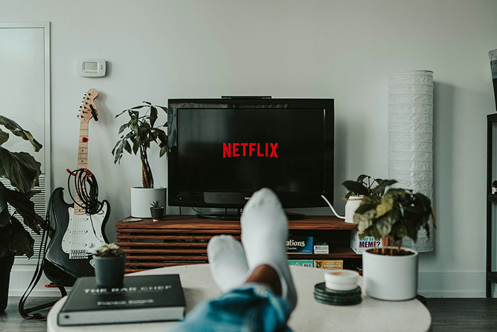Person relaxing watching Netflix on TV surrounded by plants, illustrating facts that sound unbelievable but true