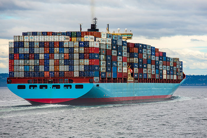 Large container ship loaded with stacked cargo containers sailing on the ocean illustrating facts that sound unbelievable but are true