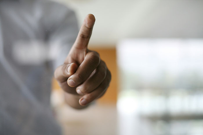 Close-up of a hand pointing forward, illustrating facts that sound unbelievable but are actually true.