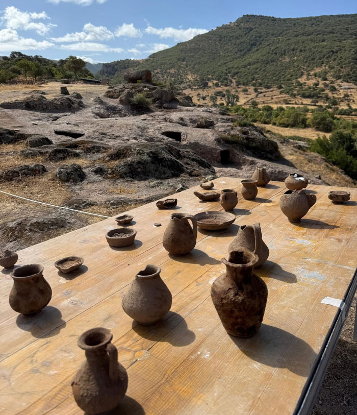 Ancient pottery displayed on a table near 5,000-year-old fairy houses carved into rock on the Italian island of Sardinia. Ancient pottery displayed on a table near 5,000-year-old fairy houses carved into rock on the Italian island of Sardinia.