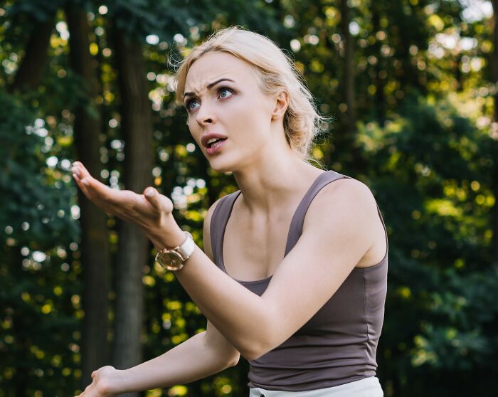 British woman showing frustration while being lectured on parenting by French shop owner during holiday outdoors. British woman showing frustration while being lectured on parenting by French shop owner during holiday outdoors.
