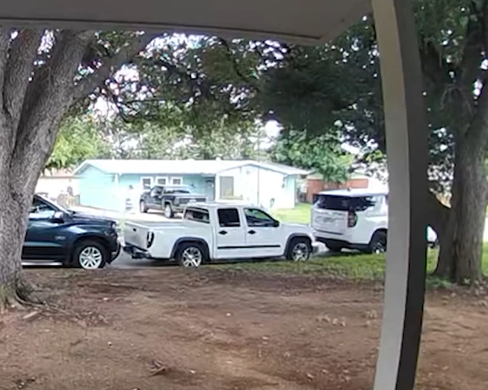 Neighborhood street with parked trucks and cars near a house, linked to flight attendant&rsquo;s mysterious disappearance arrest.