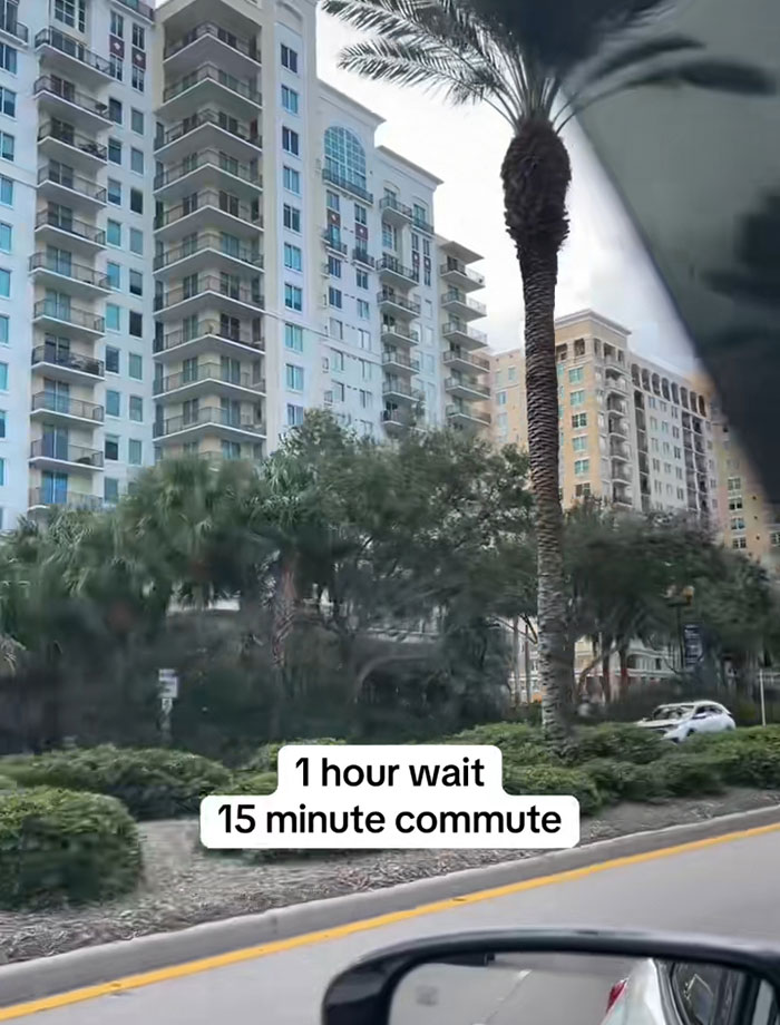 View of tall apartment buildings and palm trees from a car, highlighting food bank wait times in USA richest poor people debate.