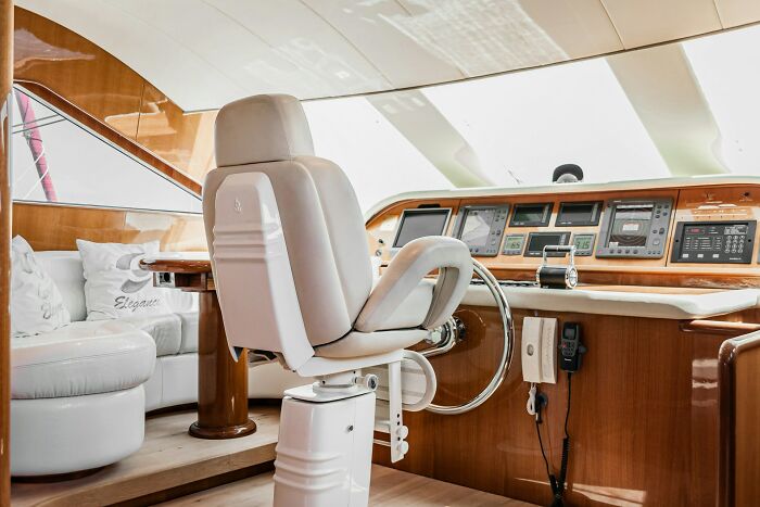 Luxury yacht helm with plush chair and high-end controls, highlighting jobs for ultra-wealthy lifestyle and services.