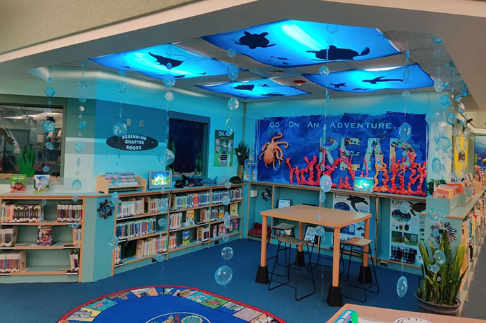Colorful children&rsquo;s library corner decorated with ocean theme, encouraging reading and learning in a vibrant setting.