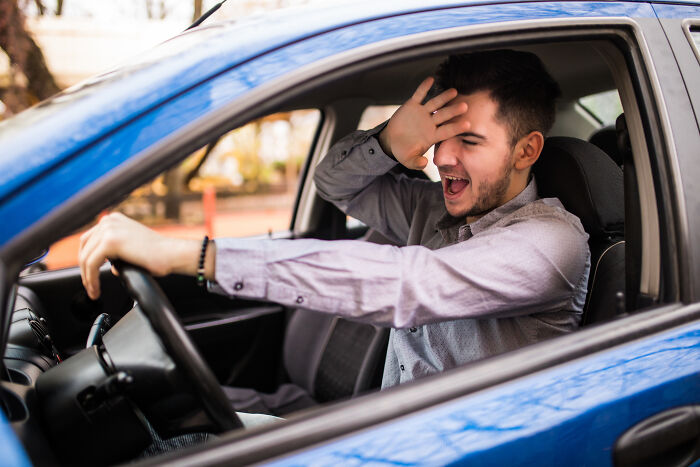 Man in a blue car showing a shocked reaction, capturing a moment that made him feel like he was definitely dead.