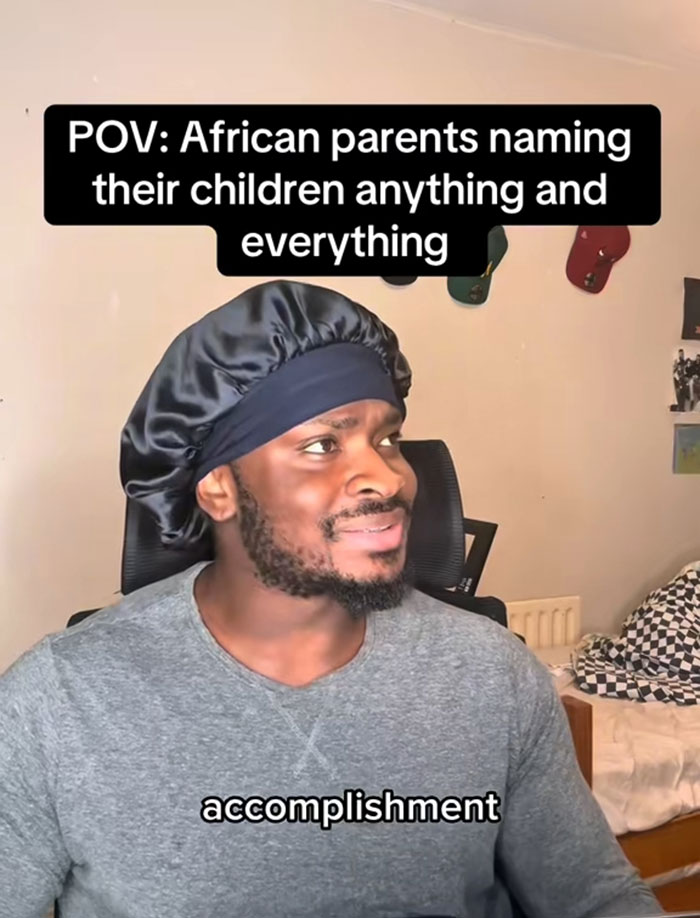 Man wearing a black satin bonnet and gray shirt reacting to unusual African names with the word accomplishment visible on screen. Man wearing a black satin bonnet and gray shirt reacting to unusual African names with the word accomplishment visible on screen.