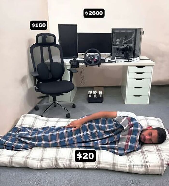 Programmer's gaming setup with expensive chair and PC, contrasted by a budget mattress where a man sleeps wrapped in a blanket.