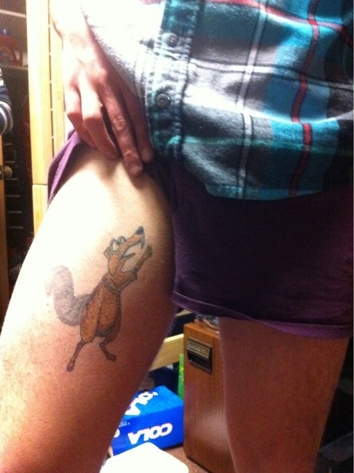 Tattoo artist shows a colorful cartoon fox tattoo on a person’s thigh, illustrating unusual client tattoo requests.