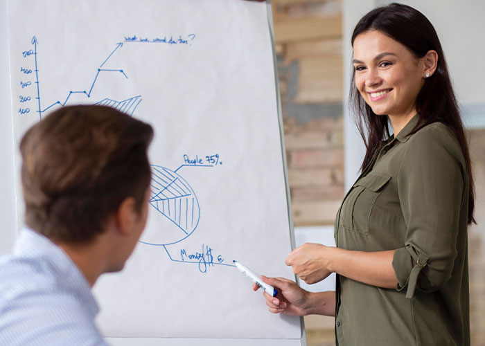 Young professional discussing business charts with colleague, illustrating client poaching after employee gets laid off