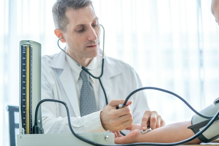 Doctor using a stethoscope to measure blood pressure of a patient, illustrating medical cases that defied odds.