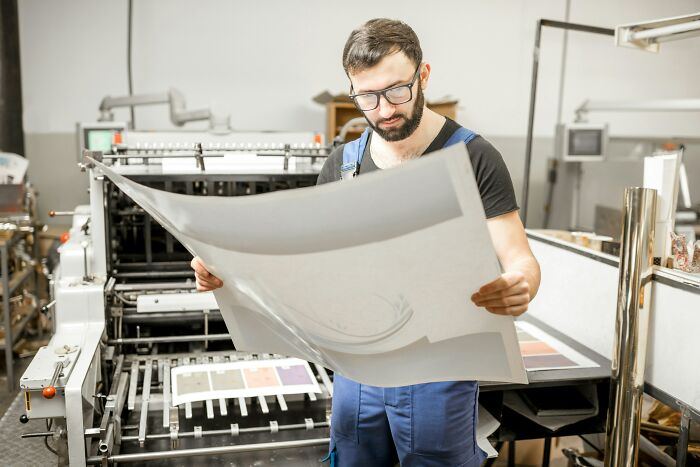 Employee reviewing print materials in a factory, demonstrating insider tricks that make their jobs easier and efficient.