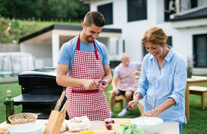 Couple preparing food outdoors smiling and enjoying time together, illustrating signs a relationship isn’t going to last.