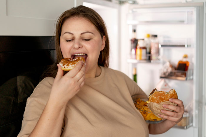 Woman eating food from fridge, representing drama over bro&rsquo;s girlfriend frequently coming and eating family food.