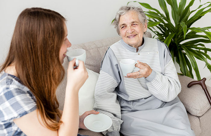 Two women sharing a warm moment over tea, symbolizing family bonds despite conflicts airing online by a half-sister stalker. Two women sharing a warm moment over tea, symbolizing family bonds despite conflicts airing online by a half-sister stalker.