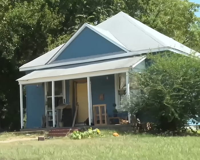 Small blue house in a grassy yard, related to grandma arrested after 11YO girl allegedly gave birth case.