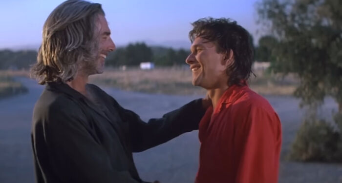 Two men smiling and embracing outdoors at sunset, representing worst-best movies that people actually enjoy.