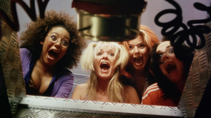 Four women looking shocked and excited inside a metal container in a scene from worst-best movies people actually enjoy.